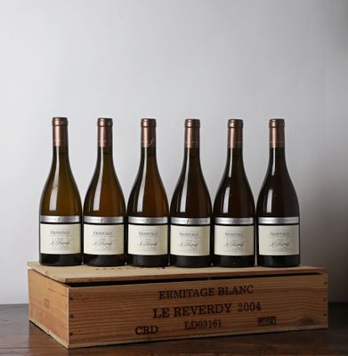 six bouteilles de vin dans une caisse en bois posée sur une table
