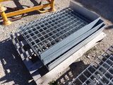 a metal grate laying on the ground next to a yellow fence