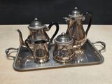 a silver tray with a silver tea set on it