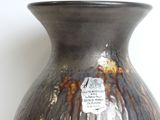 a vase with a tag on it sitting on a table