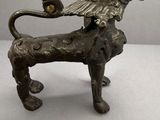 figurine en bronze représentant un lion avec un oiseau perché sur son dos