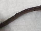 a close up of a brown leather belt on a table