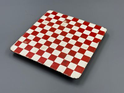 dessous de verre à damier rouge et blanc sur fond gris