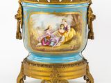 un vase bleu orné d'une peinture, posé sur un socle