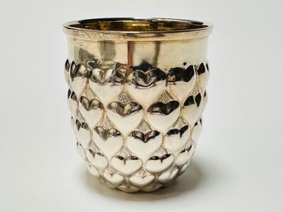 a silver cup that is sitting on a table