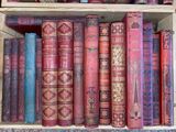 many old books on a shelf in a wooden box
