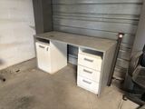 a desk with two drawers and a chair in a garage