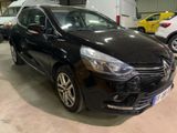 La voiture noire est garée dans le garage, à côté d'autres voitures.