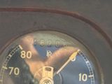 a close up view of a clock with a reflection of a person