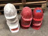 trois casques de chantier posés les uns à côté des autres sur le sol