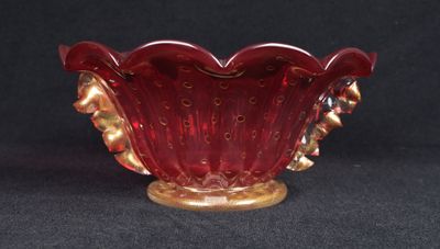 une image représentant un bol en verre rouge sur fond noir