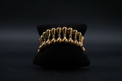 un gros plan d'une bague plaquée or posée sur un coussin noir