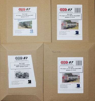 quatre boîtes de Coca-Cola sont posées sur une boîte en carton