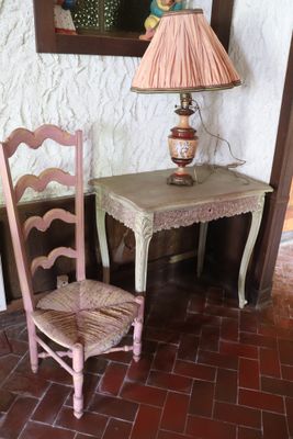 a small table with a lamp and a chair in the corner