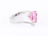 a close up of a pink diamond ring on a white background