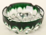 un cendrier en verre vert et noir posé sur une table