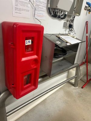 une borne d'incendie rouge sur le mur, à côté d'une autre borne d'incendie rouge
