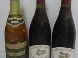 three bottles of wine are lined up on a white surface