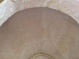 a white bowl with a brown lid sitting on a table