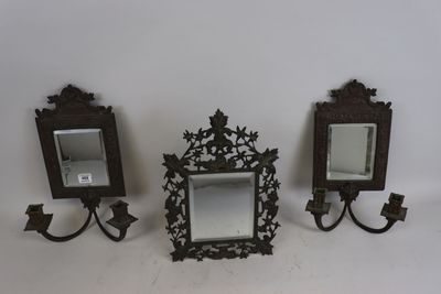 Deux miroirs et un bougeoir sont posés sur une surface blanche