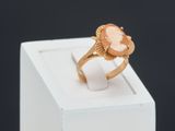 a close up of a gold ring with a pink stone in it
