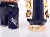 two figurines of a man and a woman standing next to each other