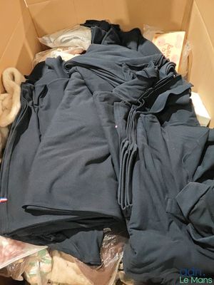 a cardboard box filled with clothes and a teddy bear