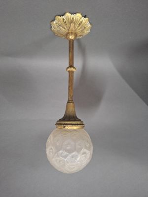 an antique brass ceiling light with a frosted glass shade