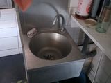 un évier dans un coin de la cuisine, avec une serviette suspendue au-dessus