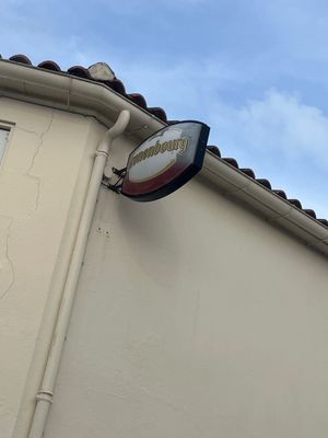 une enseigne sur le côté d'un immeuble, avec le ciel en arrière-plan