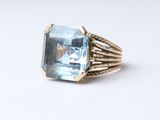 une image d'une bague avec une pierre en topaze bleue