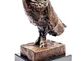 statue of an owl on a marble base on a white background