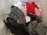 a pile of clothes in a bag on a bed