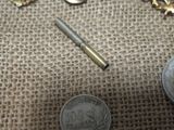 some coins and a pen sitting on top of a table next to a coin