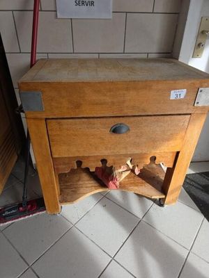 un petit meuble en bois surmonté d'un casier à bouteilles
