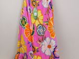 a pink floral dress hanging on a hanger on a wall