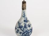 a small blue and white bottle with flowers on it