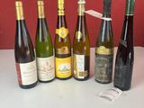 Des bouteilles de vin sont alignées sur un comptoir devant un mur rouge.