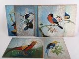 three paintings of birds are displayed on a white surface