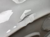 a close up of a car ' s front bumper with paint peeling off of it