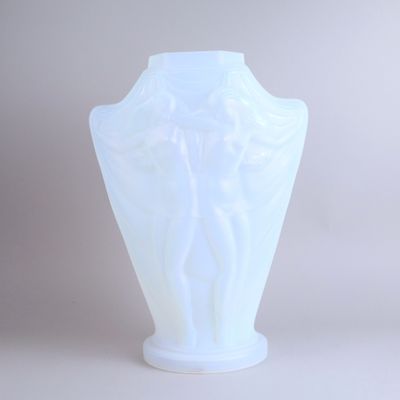 a white vase that has a statue on it