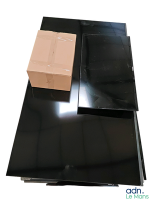 une boîte posée sur une table noire, à côté d'un carton