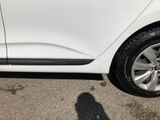 a white car parked in a parking lot with a shadow on the ground