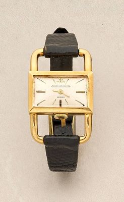 an image of a gold watch with a black strap