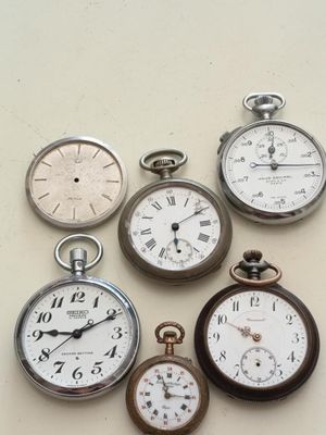 de nombreux modèles différents de montres de poche posées sur une table