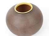 a brown vase with a yellow rim sitting on a white surface