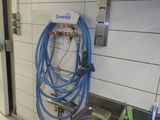 un tuyau bleu fixé au mur dans des toilettes publiques