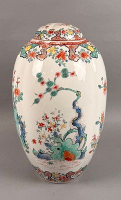 a white vase with a bird and flowers on it