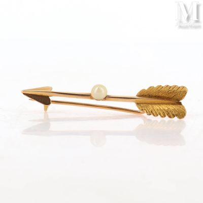 a gold hair clip with a pearl on it
