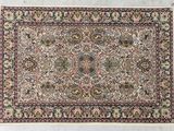 un tapis persan antique avec un motif floral sur fond blanc